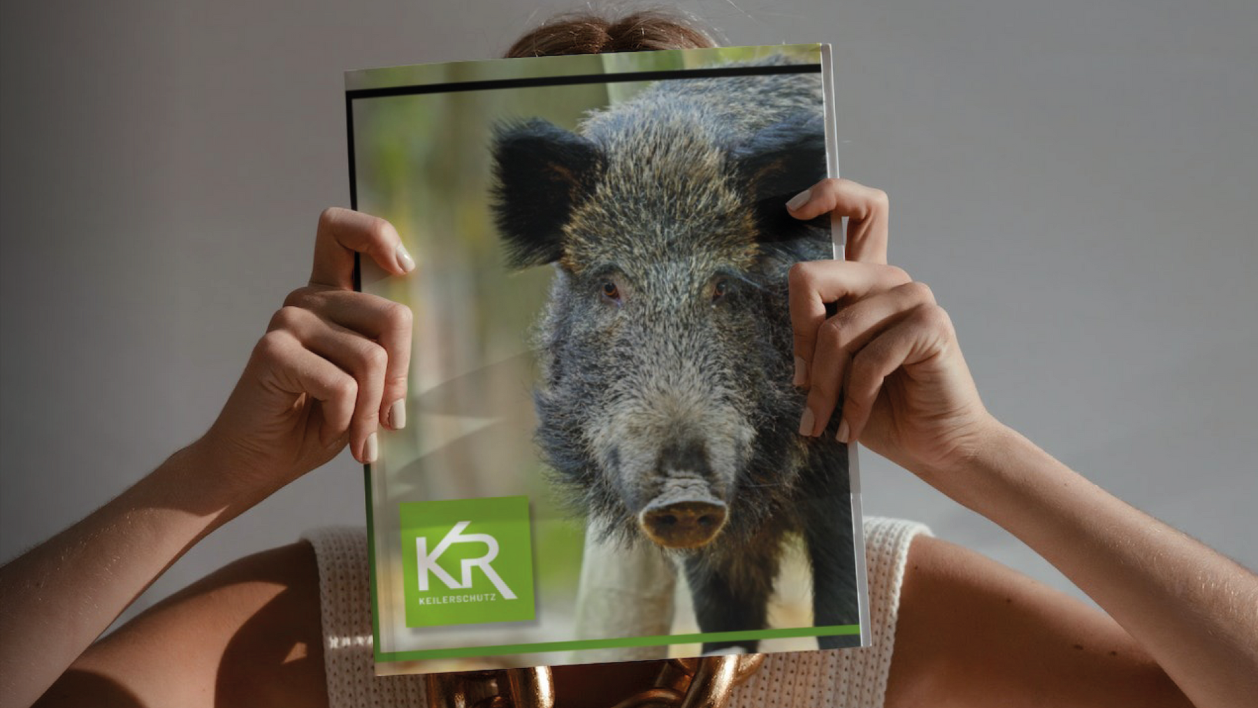 Frau mit Magazin auf dem Titel ist Kruedener-Wildschwein abgebildet.