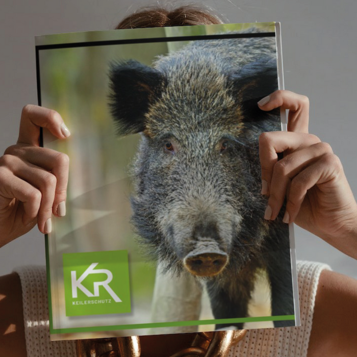 Frau mit Magazin auf dem Titel ist Kruedener-Wildschwein abgebildet.